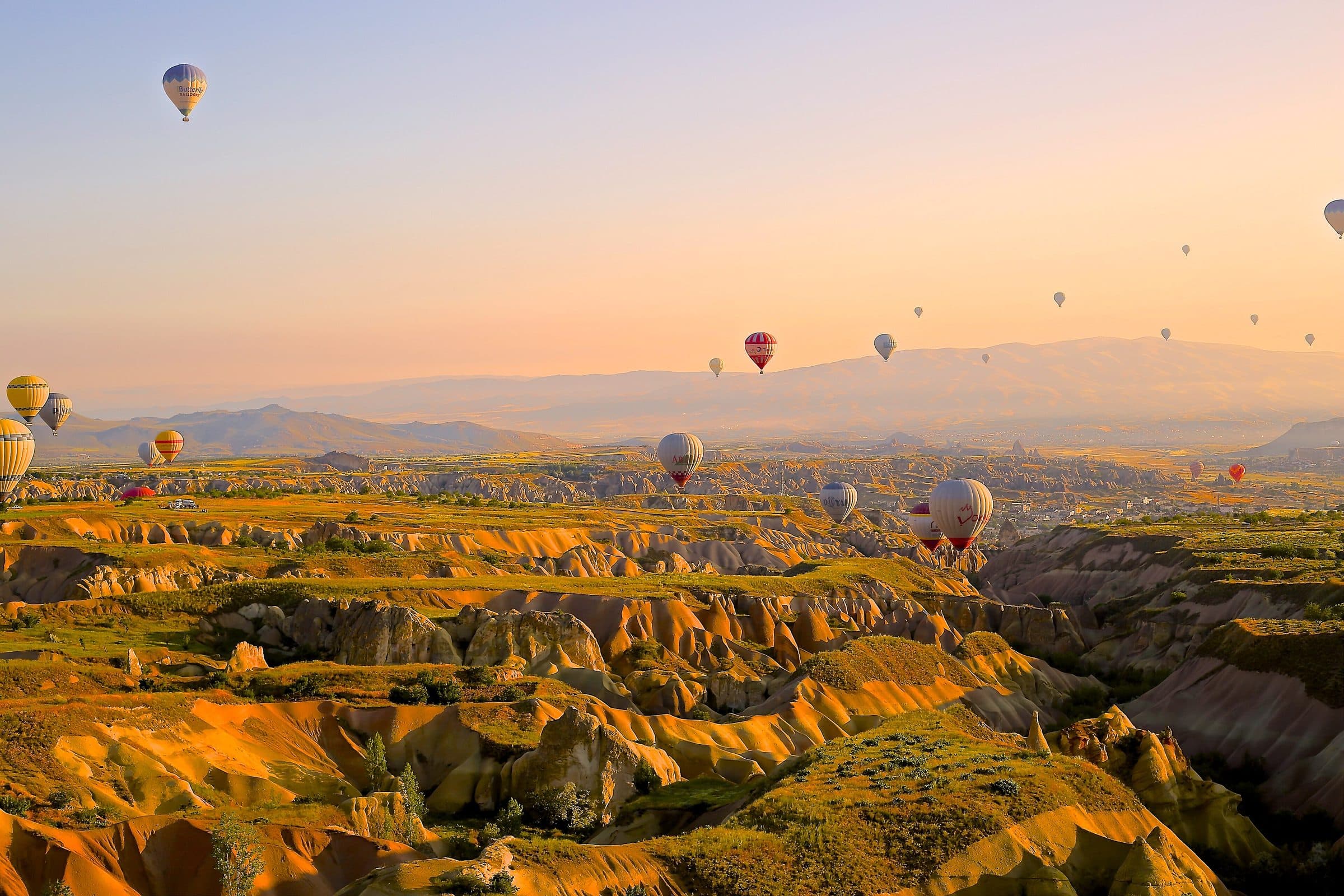 Hot air balloons drifting over the valleys of Cappadocia